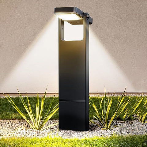 A modern solar-powered garden light with a sleek black design, illuminating the surrounding plants and gravel with dual beams of warm white light.