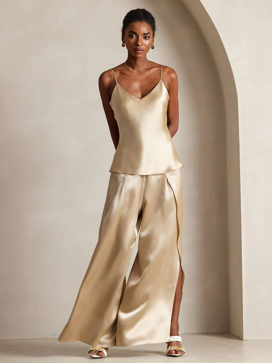 Woman in black trench coat with silk camisole and satin trousers