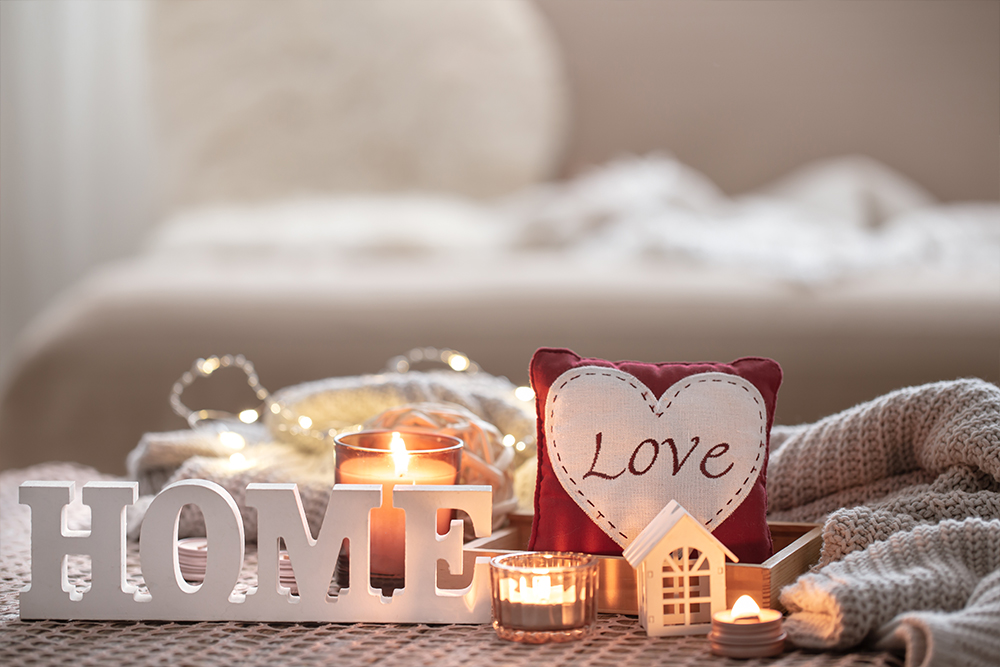 Cozy valentines day background with a candle and a decorative heart