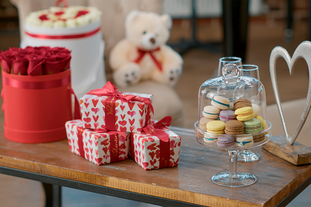 Nobody space decorated with flowers bouquet presents sweet macarons romantic gifts table empty room with valentines day surprise red roses celebrate love holiday