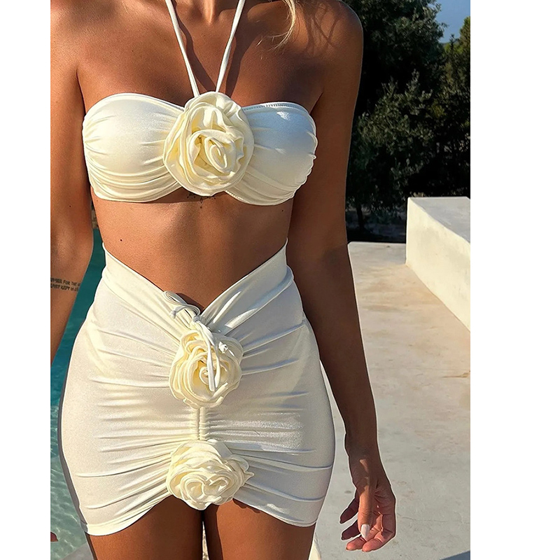 A stylish white bikini with a halter neck design and decorative flowers, perfect for a sophisticated poolside appearance.