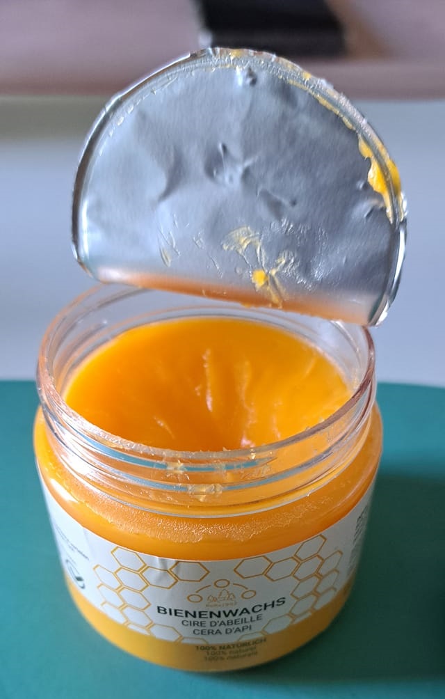 An opened bottle of beeswax, yellow paste, mainly used for wax.