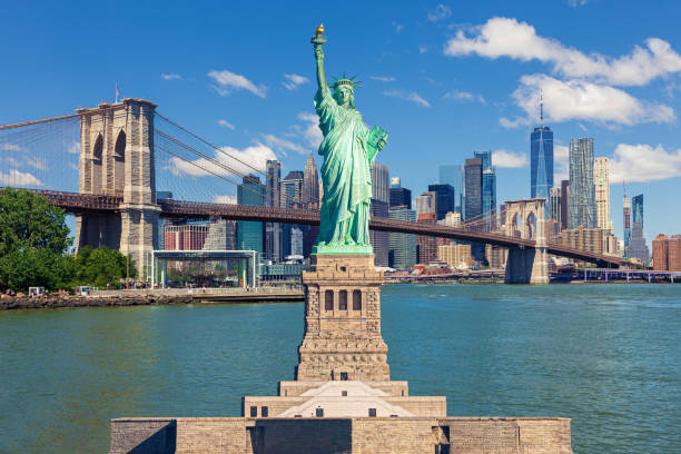 Statue of Liberty and New York City Skyline with Brooklyn Bridge, Manhattan High-Rises and World Trade Center. Statue of Liberty with Brooklyn Bridge, Skyscrapers of Manhattan Lower East Side Financial District, World Trade Center, FDR Drive, Pier 17, Brooklyn Bridge Park and Blue Morning Sky with Puffy Clouds in background, New York City, USA. Canon EOS 6D (full frame sensor) DSLR and Canon EF 24-105mm F/4L IS lens. statue of Liberty stock pictures, royalty-free photos & images
